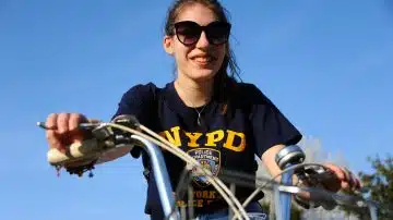 woman in black and yellow crew neck t-shirt riding bicycle during daytime